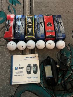 This image shows a Golf Buddy Tour handheld GPS rangefinder displaying with six Nike  Golf ball