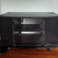 Black TV stand with glass doors and shelves.