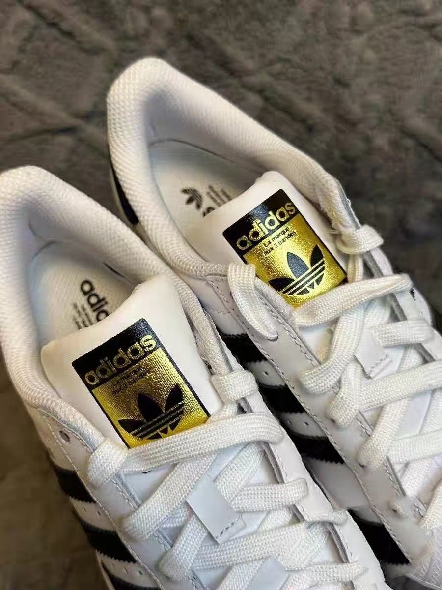 Adidas classic white shell toe shoes with the three-leaf clover logo