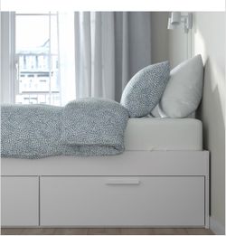 White IKEA Brimnes Queen bed with storage.
