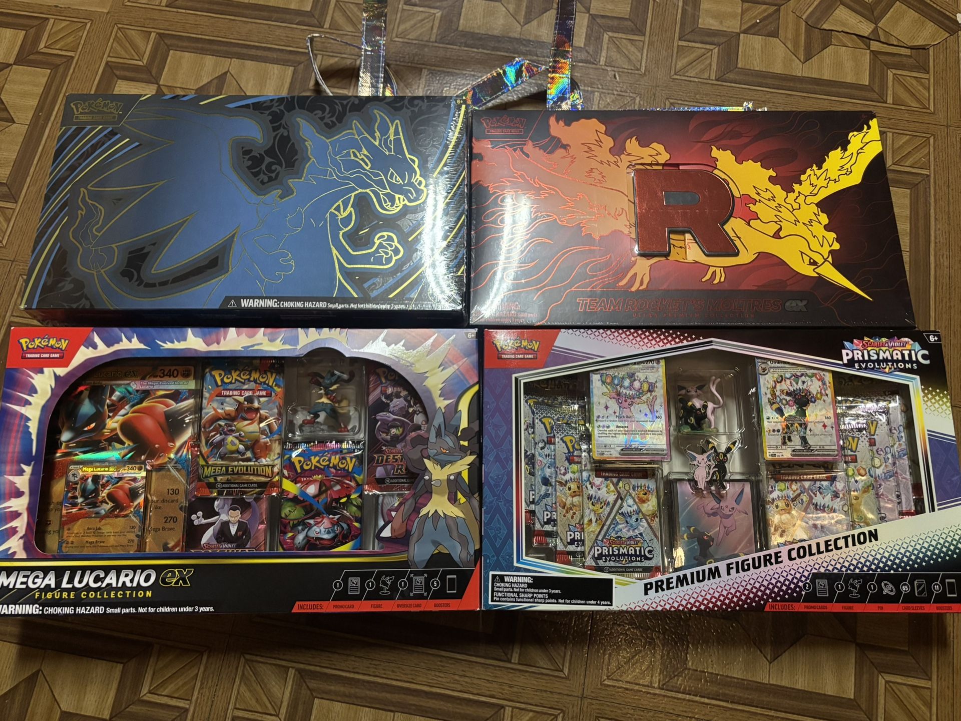 Pokémon sealed product (Team Rocket Moltres UPC, Mega Charizard UPC, Prismatic Premium Figure Collection, Mega Lucario Ex Figure Collection)