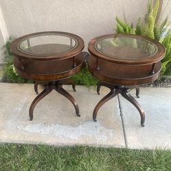 Selling two beautiful vintage end tables with glass top with caster wheels