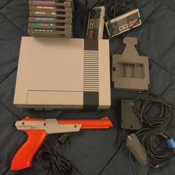 Nintendo NES system with nine games, zapper, and cleaning cartridge.