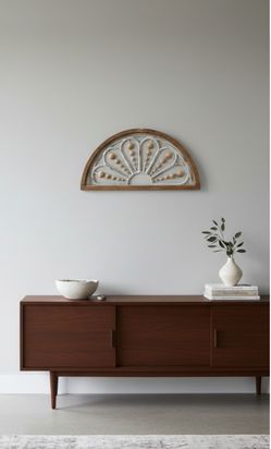 Beautiful arched wall decoration with a rustic wood frame and a decorative white sunburst design. It features natural-looking beads for a charming, fa