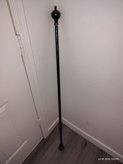 Durable metal curtain rod is black with decorative urn-style finials. The rod has a twisted texture and includes a matching end cap.
