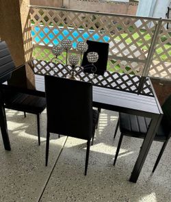 Glass dining table with four chairs. Like new.