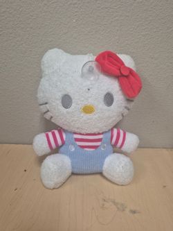 Sanrio Hello Kitty plush featuring blue overalls and a red bow.