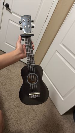Black ukelele with capo