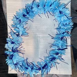 Light Blue Flowered Lei With Royal Blue Tinsel Inserts Between Flowers