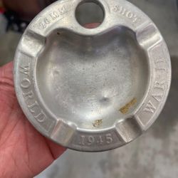 This is a piece of WWII trench art made from a 20mm shell casing and aluminum, functioning as a commemorative ashtray. 