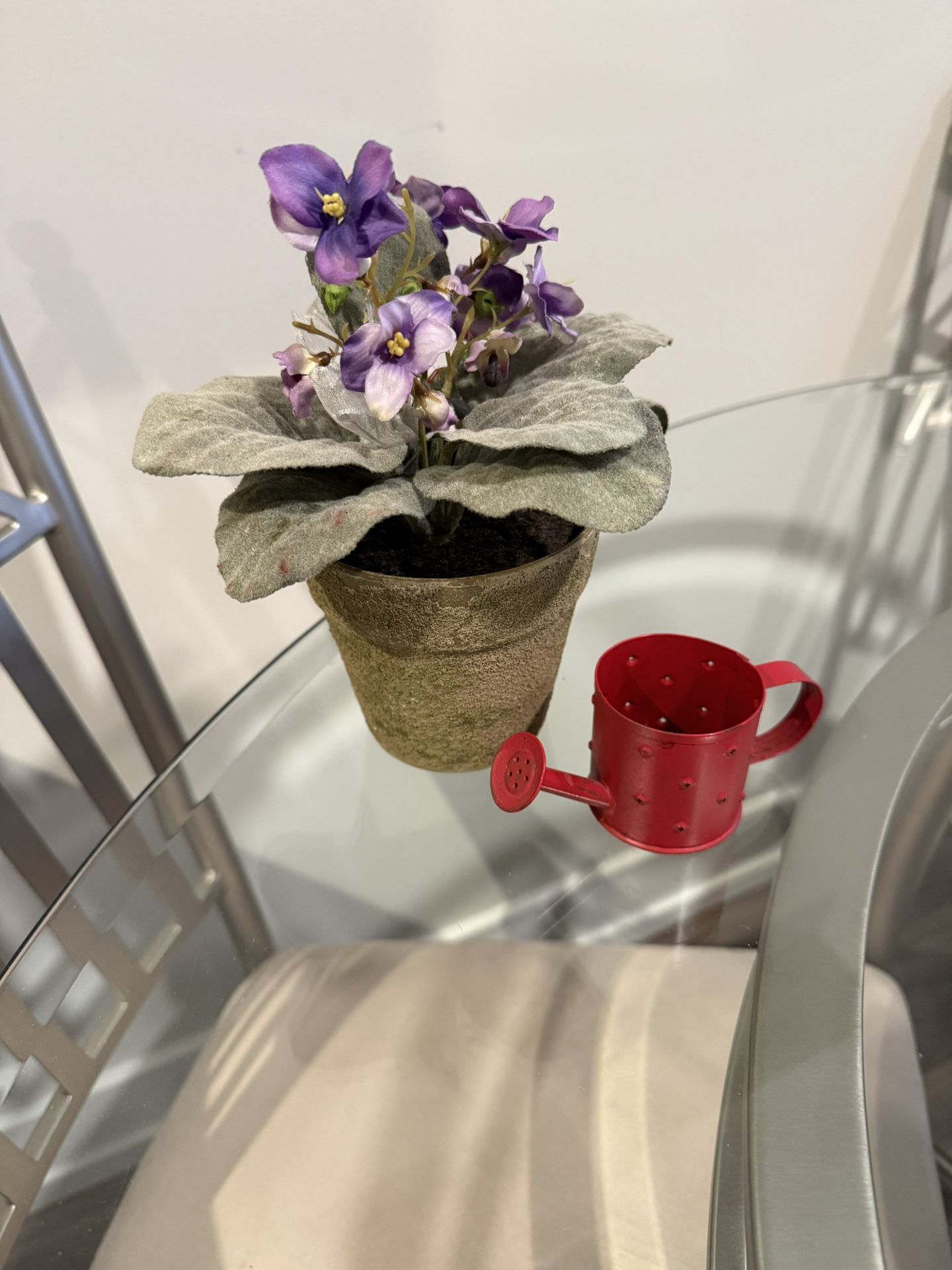 Purple artificial flower with watering can candle tea light holder