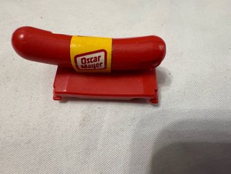 original vintage red plastic Oscar Mayer Wienermobile promotional whistle toy. It features the iconic bright yellow Oscar Mayer logo band wrapped arou