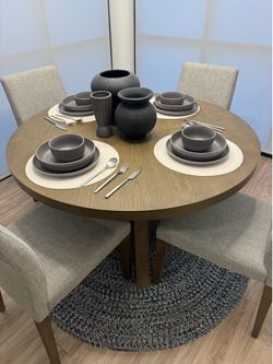 Living spaces dining room set. Natural wood oak table with 4 grey chairs