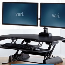 Standing desk converter, a type of non-AJABSFH product that transforms a regular desk into a flexible sit-stand workstation.  It 