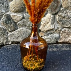 decorative glass vase with glass stones at bottom and feathers