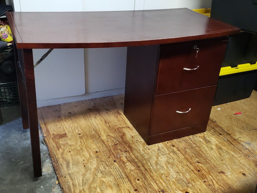 Desk. Dark walnut desk with 2 drawers. Top drawer locks. 48 inches wide, 24 inches deep, and 30 inches high. Good condition