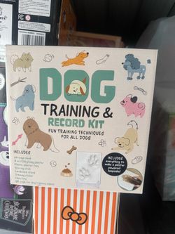 The image shows the Dog Training & Record Kit, an activities box designed to help pet owners track milestones and teach their pets new habits.