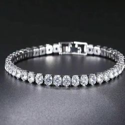Elegant sterling silver tennis bracelet is set with round-cut cubic zirconia stones. The piece has a secure box clasp with a safety latch and is stamp