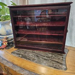 Hanging cabinet with latched glass door. Produced for gold ball display, but hangs either way and can be used to display other small trinkets. 