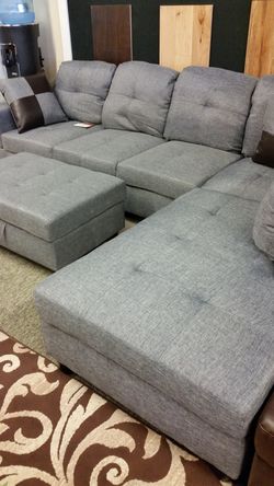 Blueish grey sectional with a matching storage ottoman