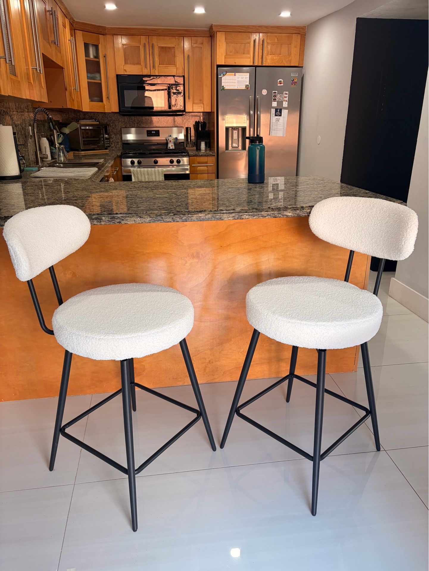 Pair of white swivel boucle bar stools