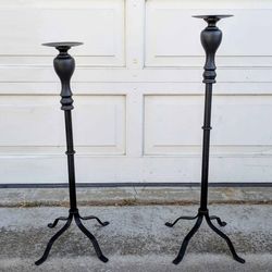 Pair of two black metal lightweight decorative uneven height portable tall candleholder floor stands