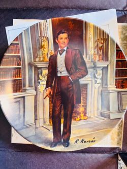 This collectible porcelain plate depicts Rhett Butler from Gone with the Wind, featuring artwork by Raymond Kursar and produced by Edwin M. Knowles