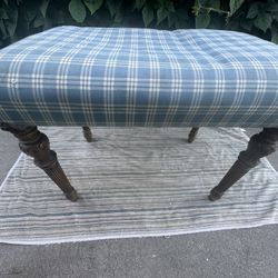 Upholstered Plaid Ottoman With Carved Wooden Legs Serves As Footrest. Seating Or Even Small Side Table