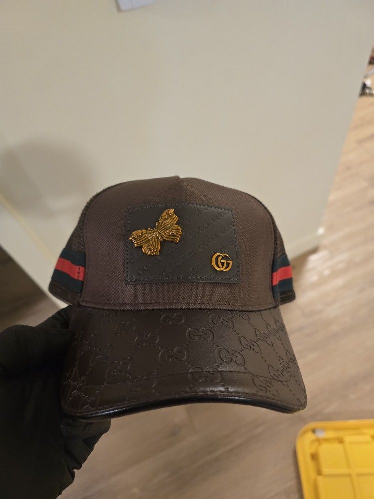 Gucci GG Supreme baseball cap with a gold butterfly appliqué.