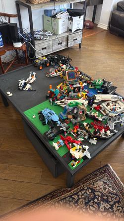 Lego table with lots of Lego pieces and already built Legos