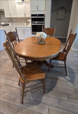 Solid Oak Dining Set with a pedestal base table with 4 chairs. Used, in good condition. Normal Wear! 2 of the chairs are missing wood spindles. 

Tabl