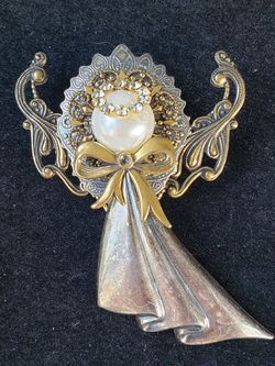 $9. Angel brooch with Crystal Halo. Silver toned and gold toned by Kat's Creations. 2 1/4-in long and 1 7/8-in wide.