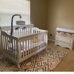 Includes a crib with Matress and protective cover with mobile and a changing table cushion, cover , dresser with storage baskets.