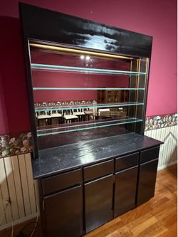 Large black lacquered display hutch illuminated with glass shelves and mirror $150