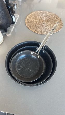 The Nordic Ware Basalt 3-Piece Skillet Set features 8-inch, 10-inch, and 12-inch frying pans crafted from pure aluminum with a Swiss-made 3-layer cera