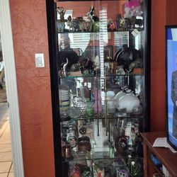 Display cabinet with glass shelves and light. The exterior is black.