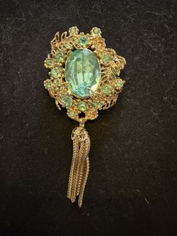 vintage Florenza gold-tone brooch featuring a large oval aqua green rhinestone