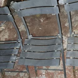 Four Patio bistro-style metal folding chairs