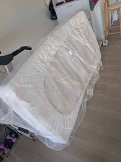Twin bed frame pink with mattress in protection cover
