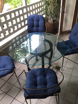 Glass table with chairs and cushions