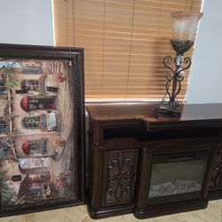 A 56x31 framed painting, a 60x12 TV stand with a fireplace, and a lamp.