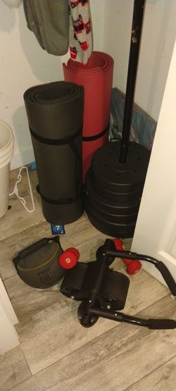 Exercise equipment includes weights for barbell workouts, exercise mats, and small weights.