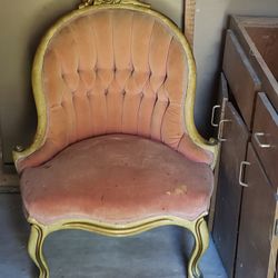 antique Victorian Rococo Revival parlor chair with a tufted pink velvet seat and a carved wooden frame. 