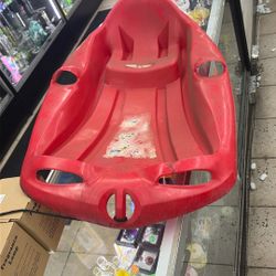 red plastic snow toboggan sled for recreational winter use