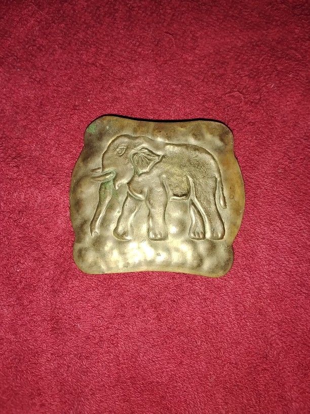silver-toned elephant-themed item, likely a brooch, pin, or pendant. 