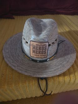 Visión general creada por IA                      Este sombrero de vaquero de paja color beige presenta un parche de cuero "Los Meros Meros Carne Asad