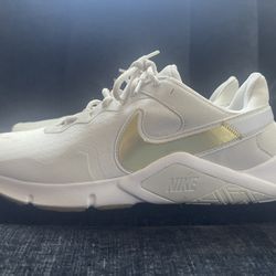 Size 12  Nike Women's Legend Essential 2 training sneakers in white and gold.