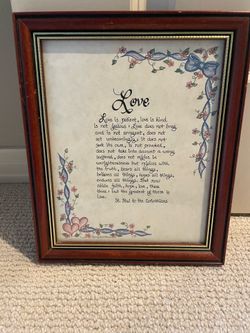 Wall art features 1 Corinthians 13 calligraphy in a dark wood