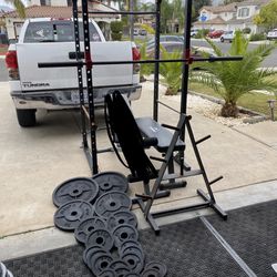 Squat rack/ bench press with 7ft 45lbs bar with 295lbs of Olympic weights and weights tree
