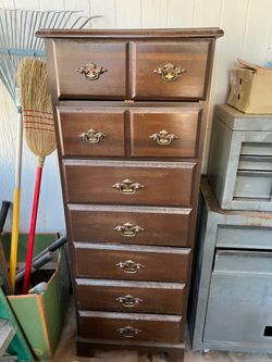This is a vintage tall narrow lingerie dresser featuring multiple drawers and brass hardware.